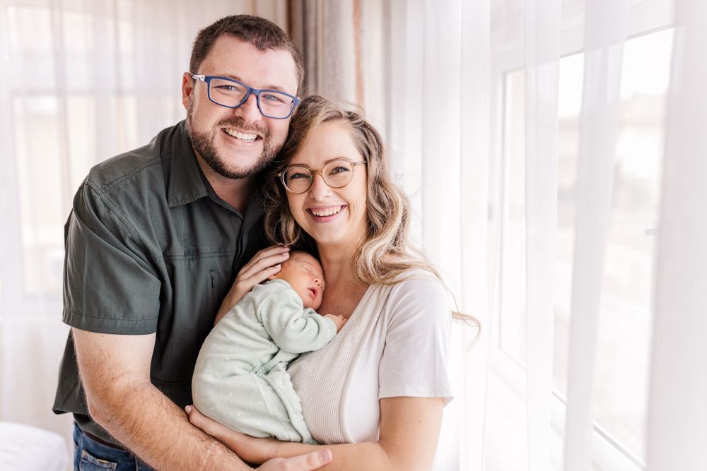 A family holding a newborn, capturing connection in Maputo, Mozambique, by Mercy Koimburi Photography.