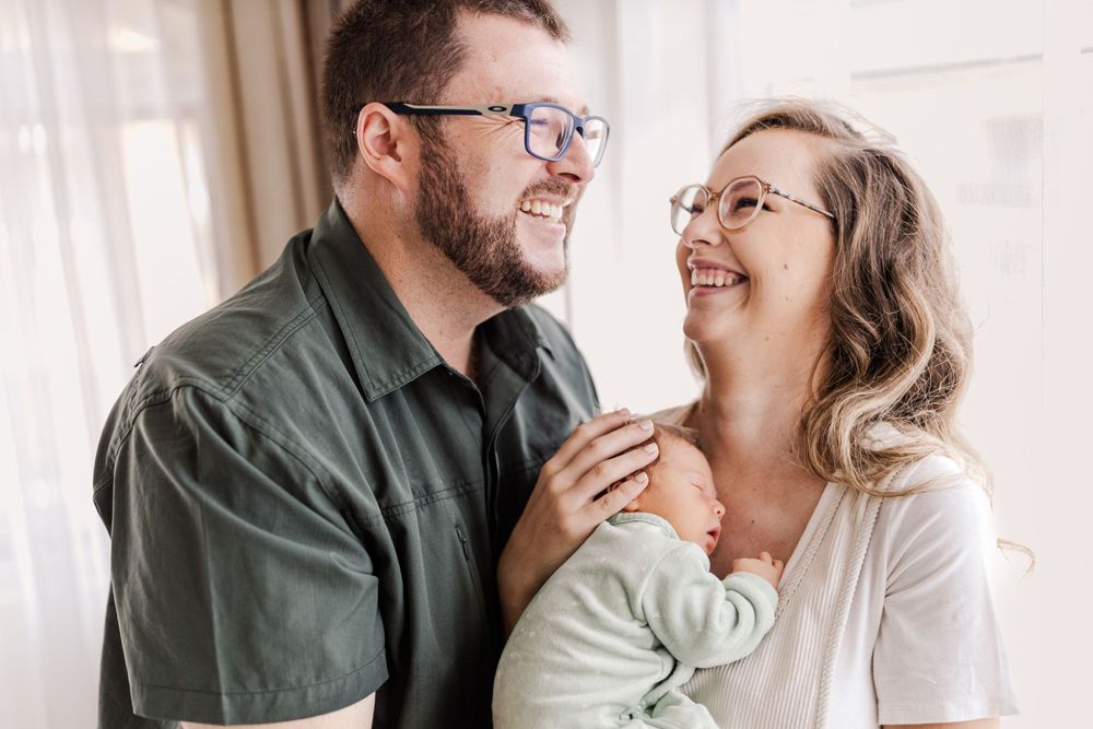A family holding a newborn, capturing connection in Maputo, Mozambique, by Mercy Koimburi Photography.