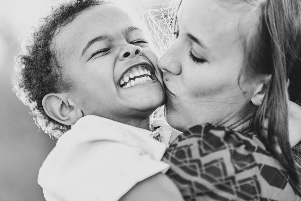 A mom kissing the baby's cheek showing love and connection in Maputo, Mozambique.