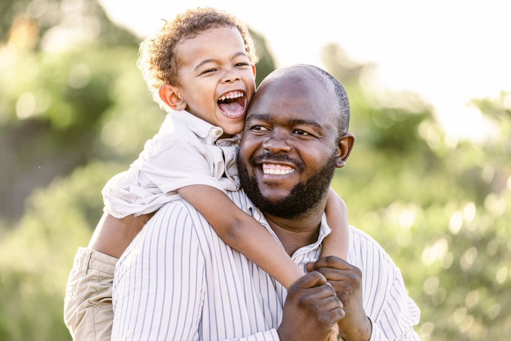 Father with a joyful son on his shoulders in Maputo, Mozambique.