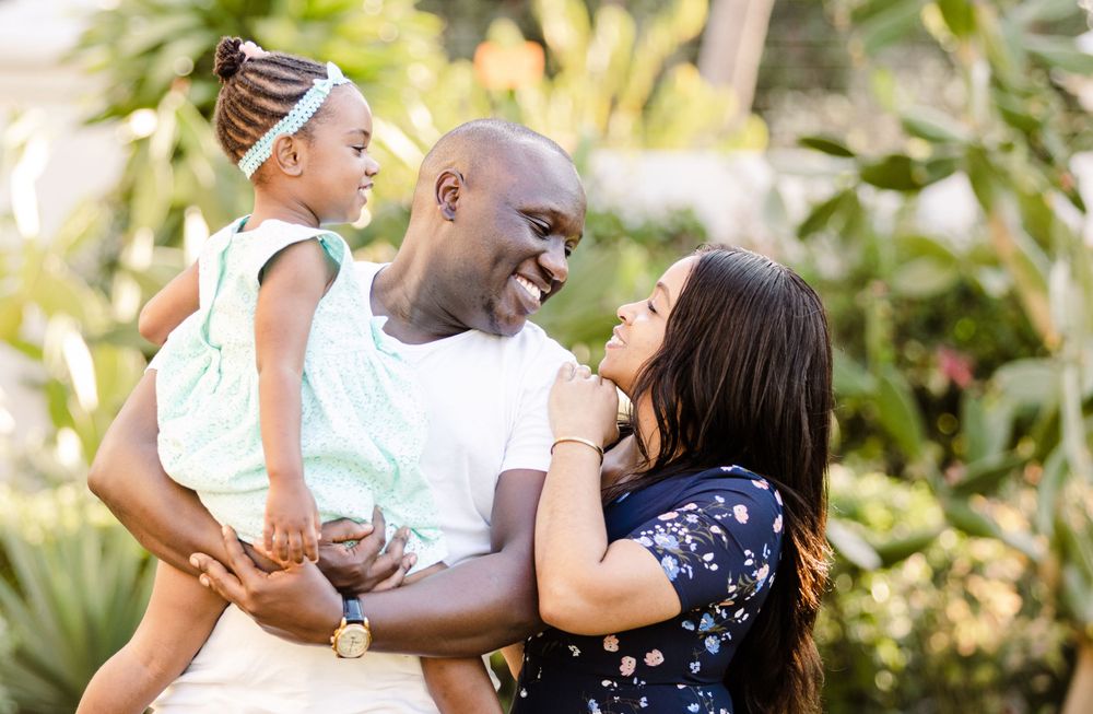 Black family portrait of father, mother and daughter in a garden in Maputo Mozambique