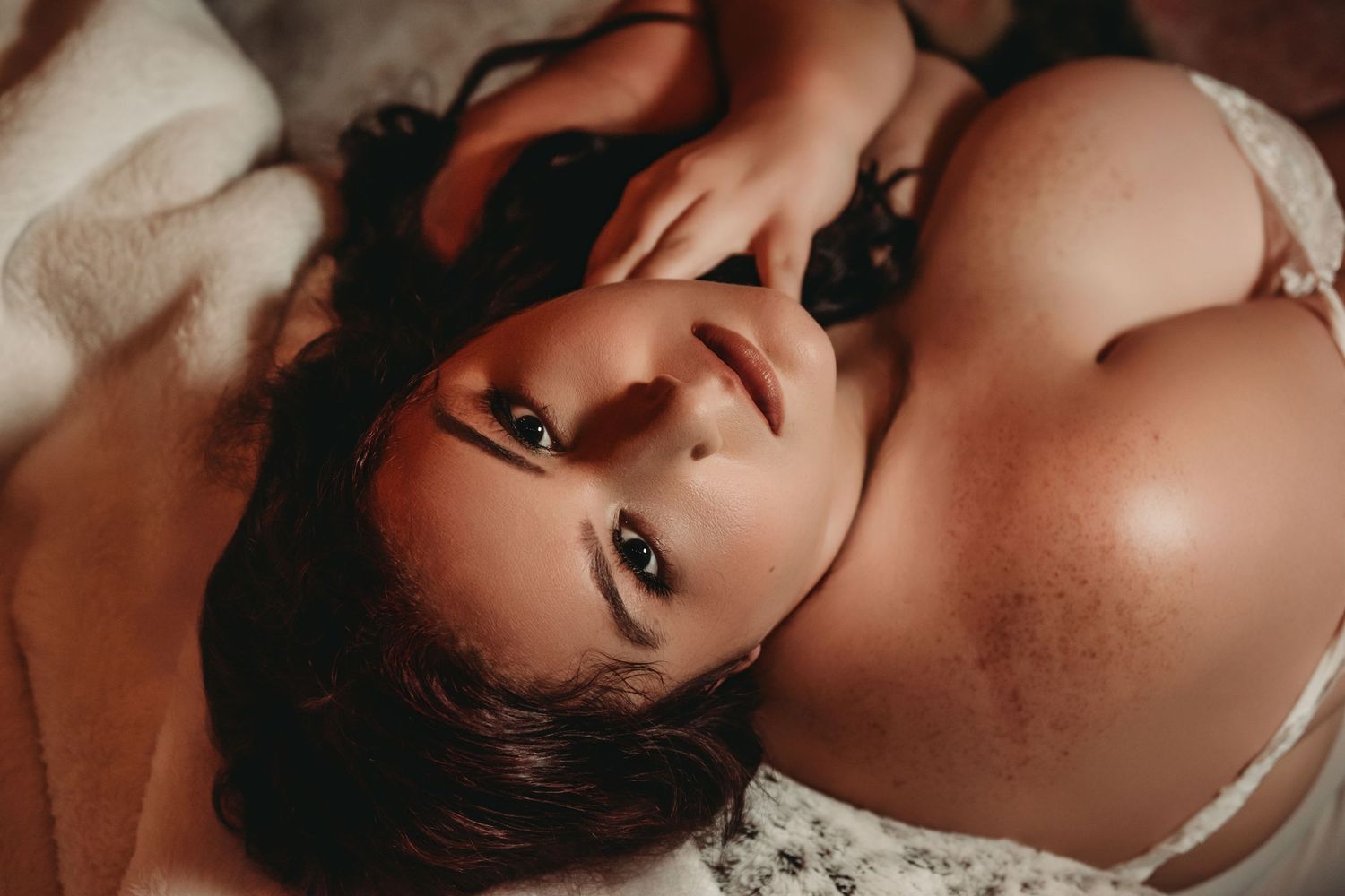 Confident plus-size woman in intimate beauty portrait during boudoir session.