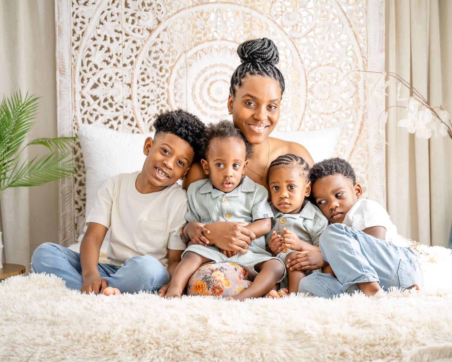 Cozy indoor portrait of a family group sitting together on white fuzzy carpet.