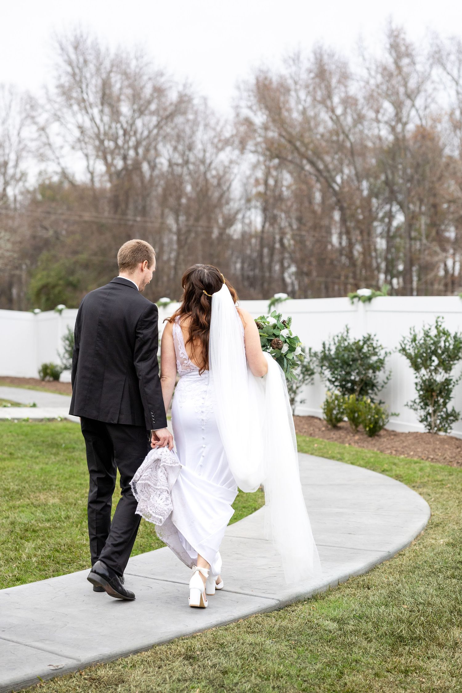 A newlywed couples walks on a path at the House on Barber Mill Clayton NC