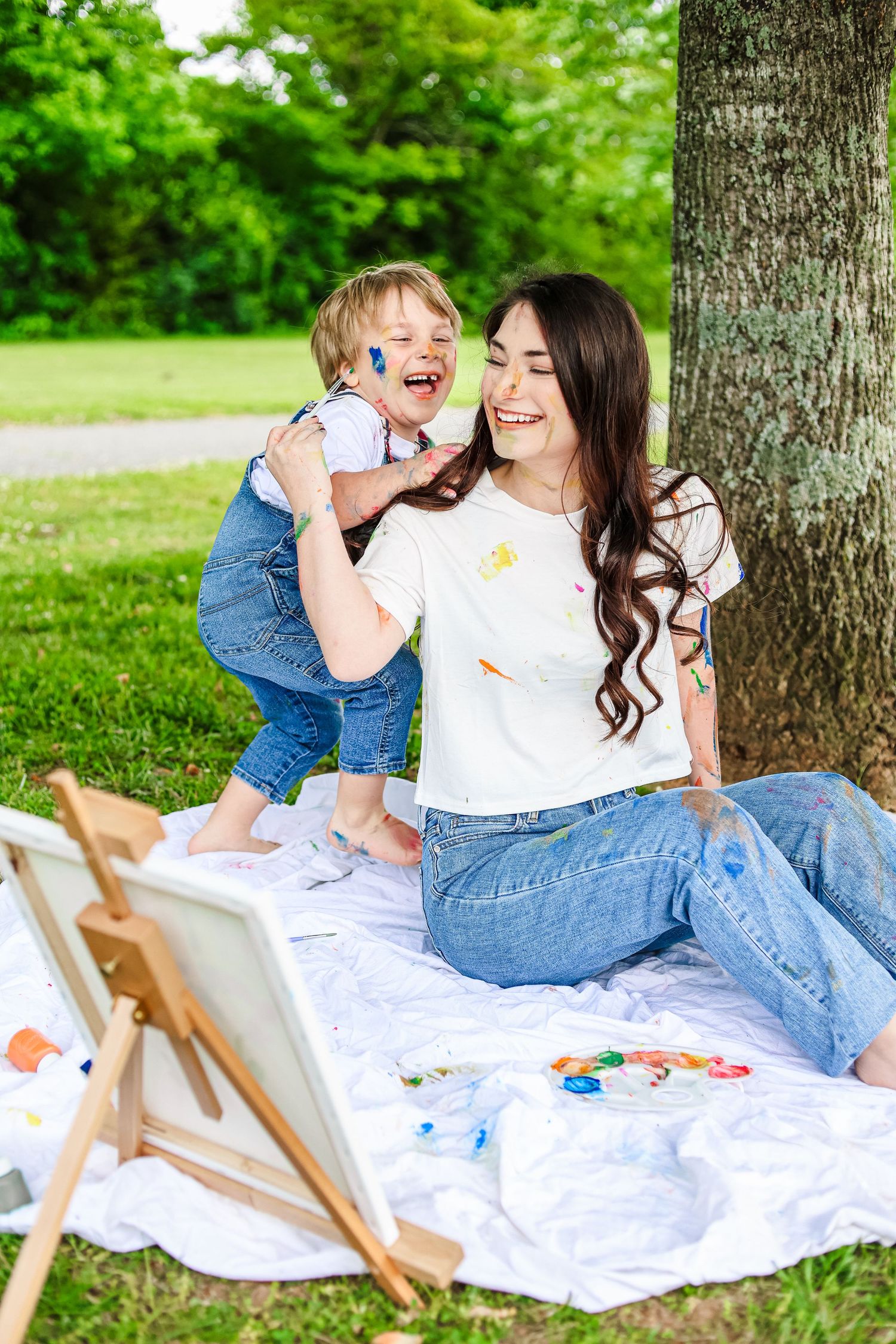 A candid image of a mother and son painting each other.