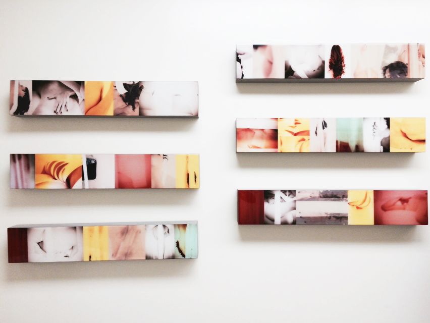 Series of small artistic photographs arranged on white floating wall shelves.
