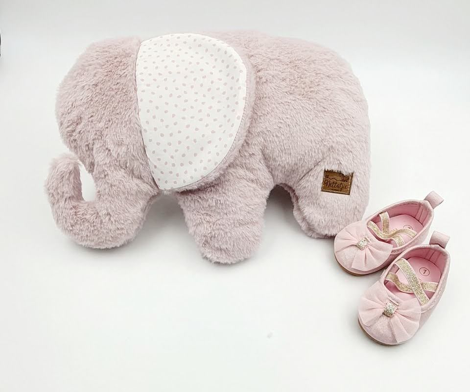 Light pink plush elephant with polka dot pattern ears beside pink ballet shoes.