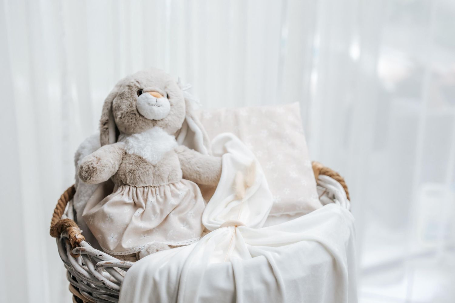 Plush toy and white fabric arrangements in soft, dreamy lighting.