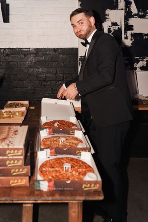 Collection of sequential images showing person in suit signing paper documents on a wooden surface in a dark room.