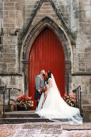 A sequence of wedding photos showing a couple in front of red church doors with stone archways and floral decorations.