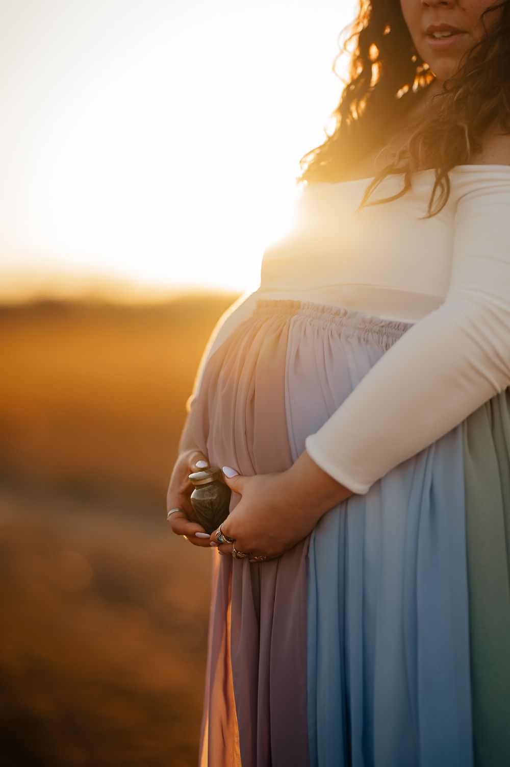 A maternity photoshoot at golden hour shows a close-up of a flowing dress against a sunset backdrop.