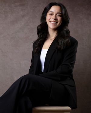 Professional studio portrait showcasing a classic black blazer and white top combination.