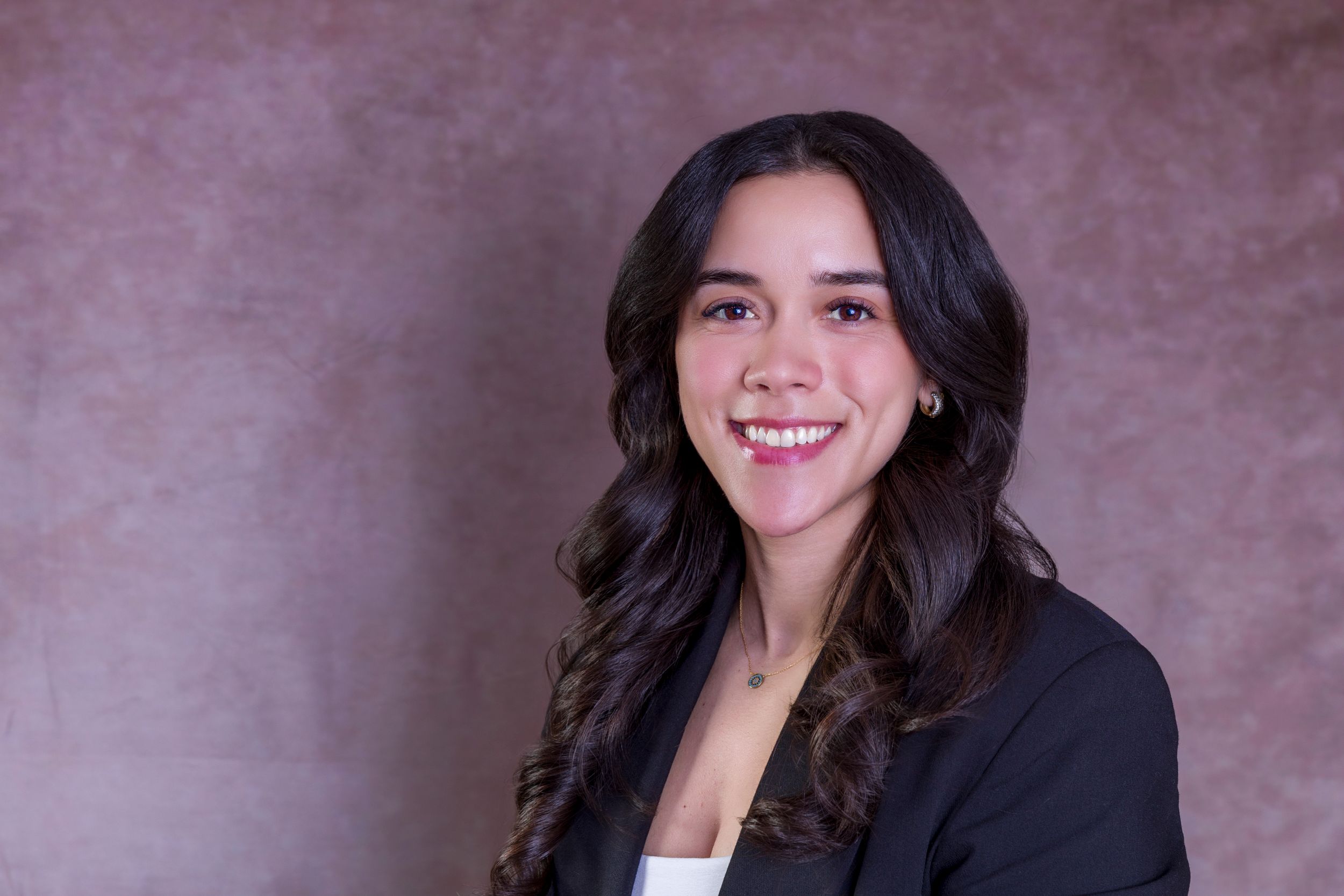 Studio headshot with soft lighting featuring business professional attire.