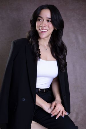 Stylish professional portrait combining a black blazer with casual white top.