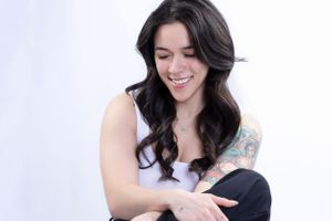 Candid studio shot capturing genuine laughter in casual attire.