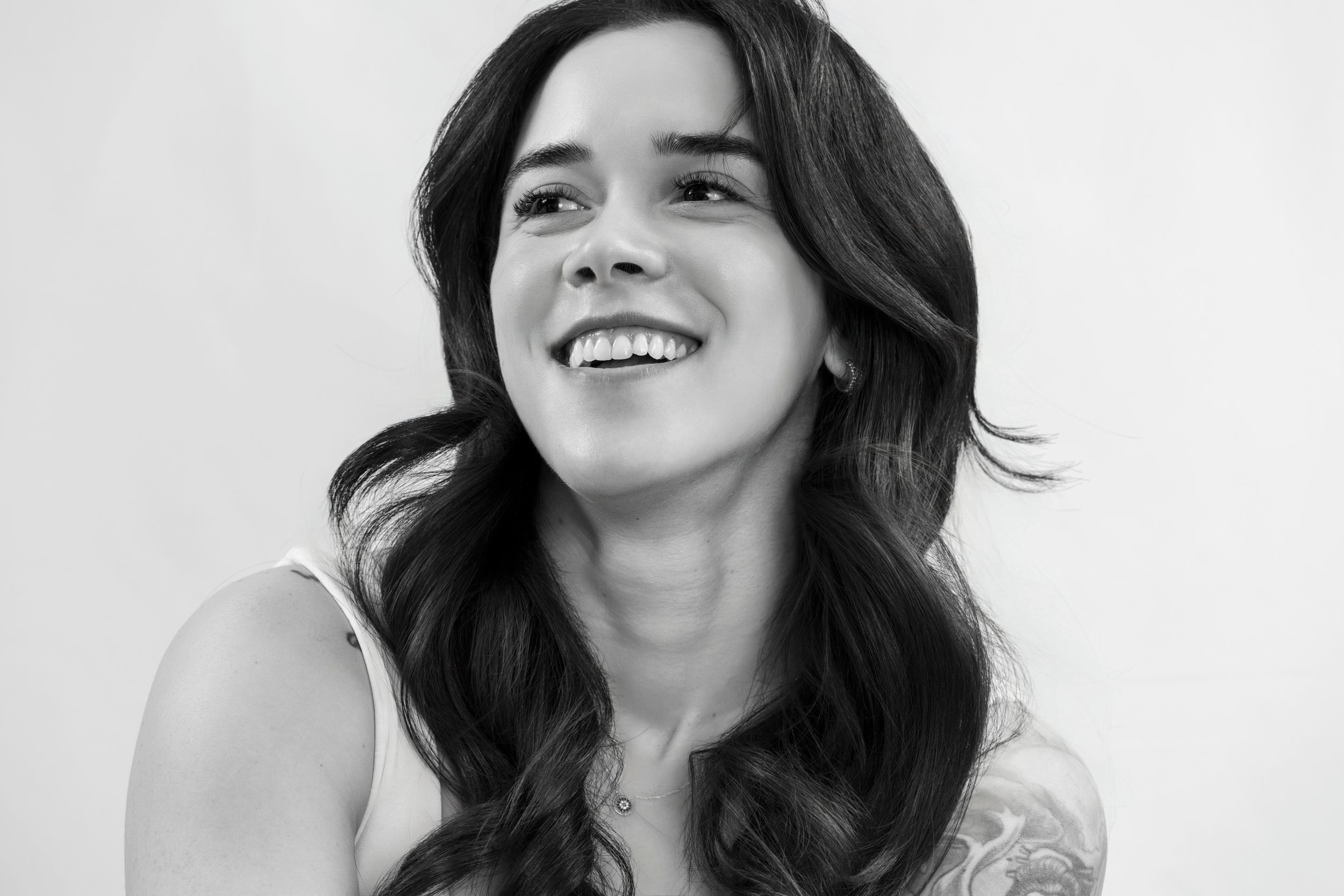 Black and white portrait capturing joyful expression with natural wavy hair.