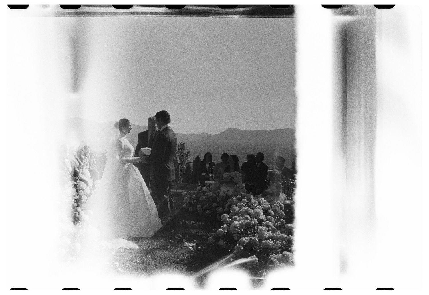 Bride, groom and guests at a welcome dinner during a destination wedding in Puglia, Italy, captured in candid black and white