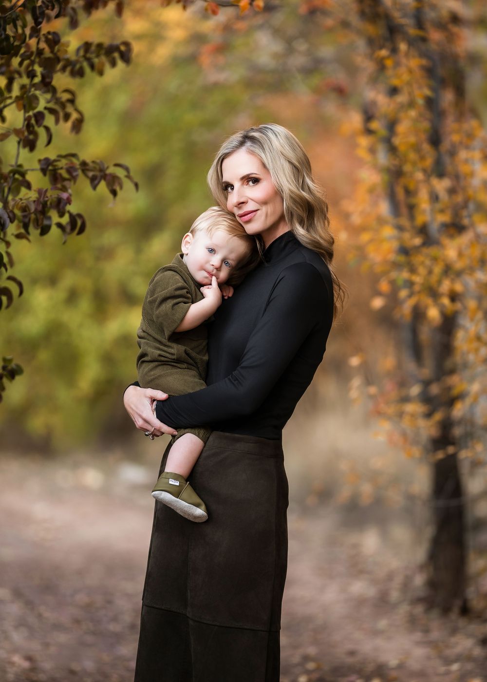 Tender autumn outdoor portrait showing loving embrace against backdrop of fall foliage.