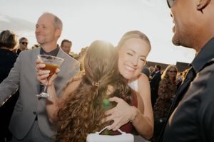Wedding guests mingling and socializing during a sunny outdoor reception celebration.