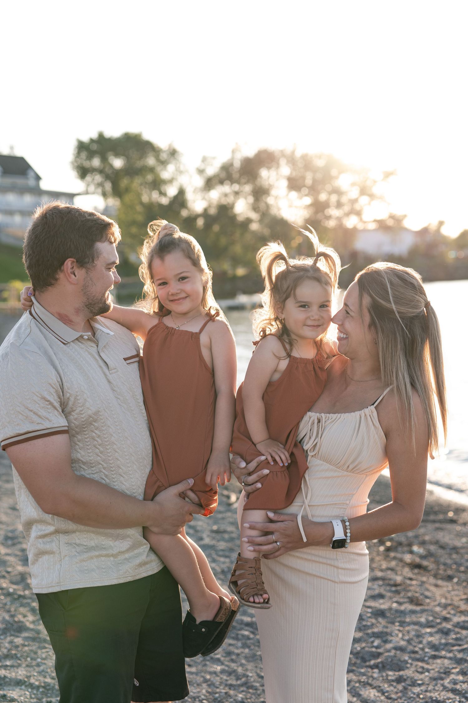 A family poses together on a wooden bridge surrounded by fall foliage.