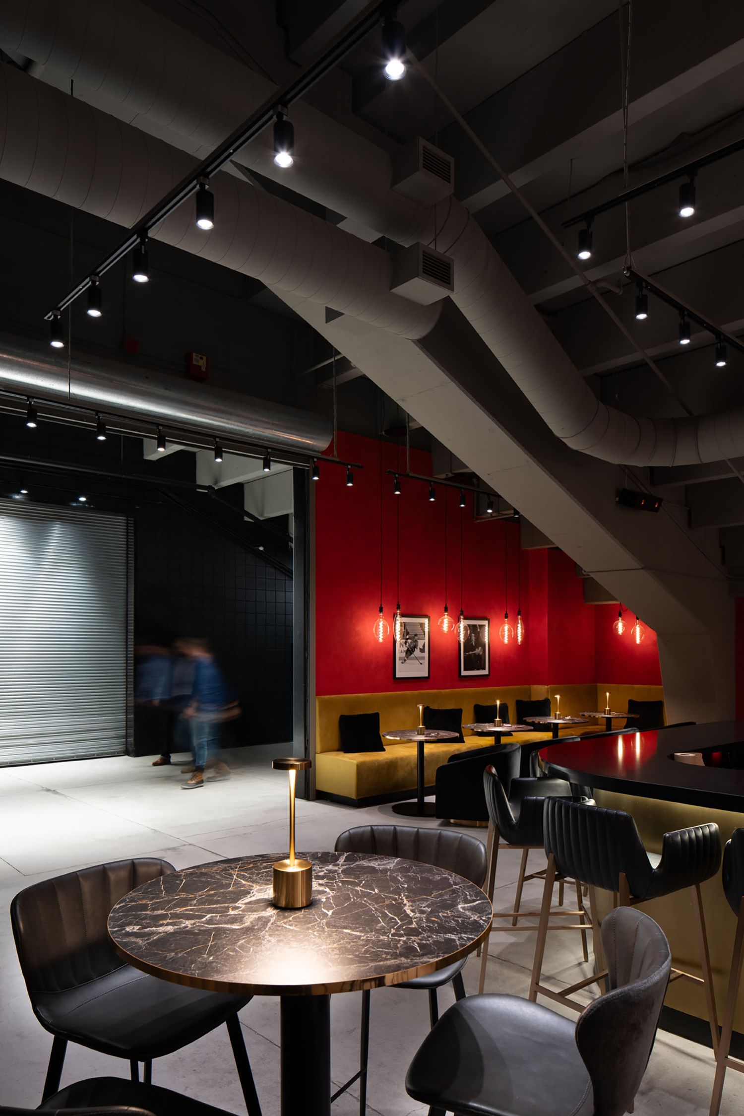 Detailed interior shot of a marble bistro table and velvet seating, highlighting architectural lighting and textures in a luxury lounge