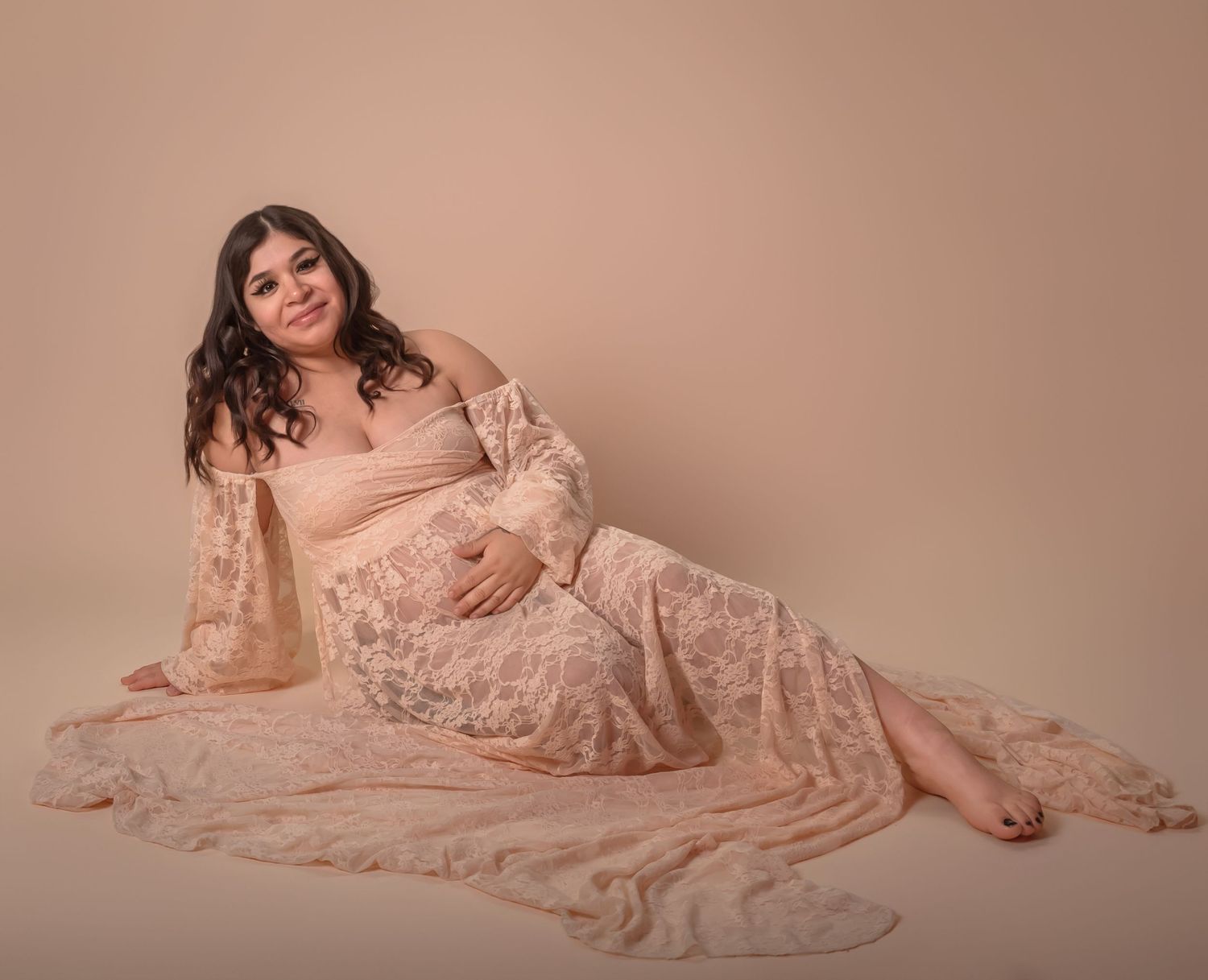 Maternity portrait of woman in olive green maxi dress standing outdoors during autumn.