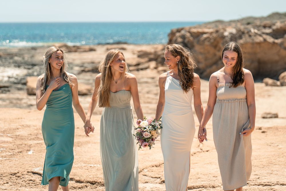 bride and bridesmaids walking and laughing on a sunny day on the cliffs in Torrevieja Spain