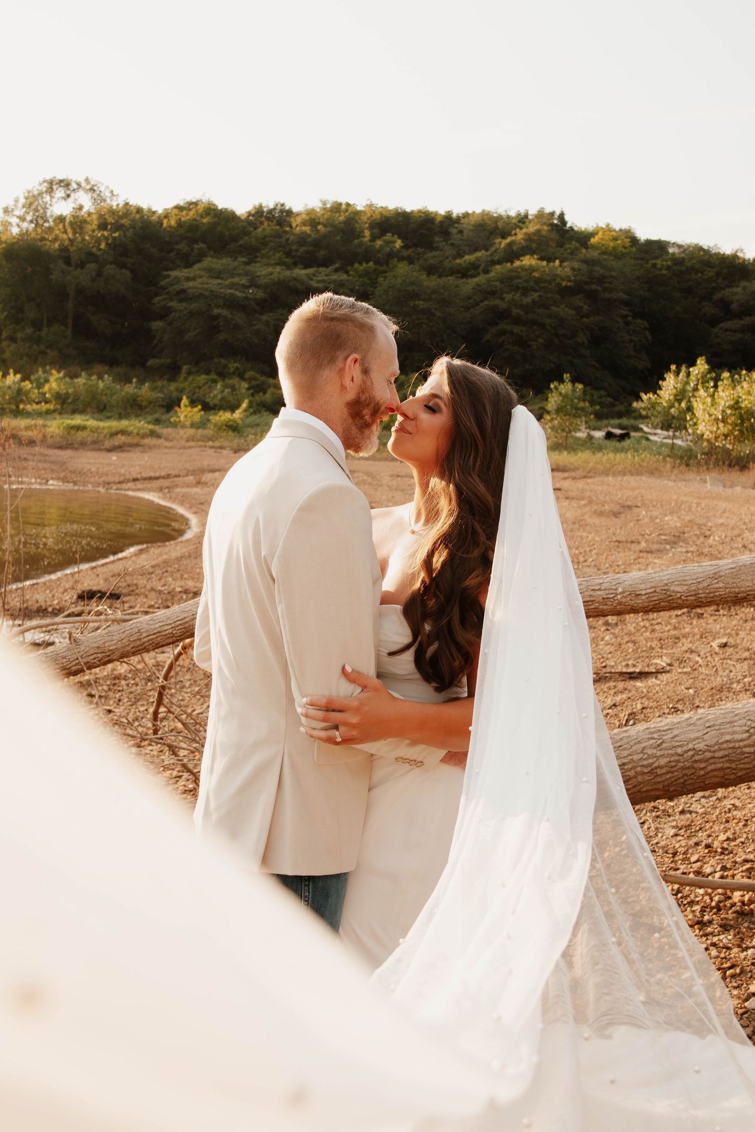 A bride and groom share a tender moment during their outdoor wedding day photos.