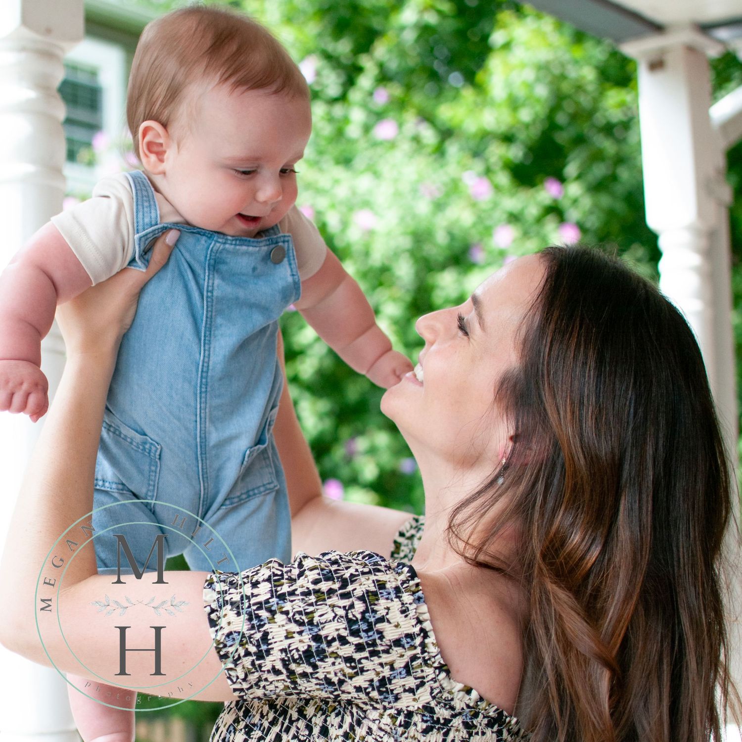 Mom holding baby boy up smiling photo