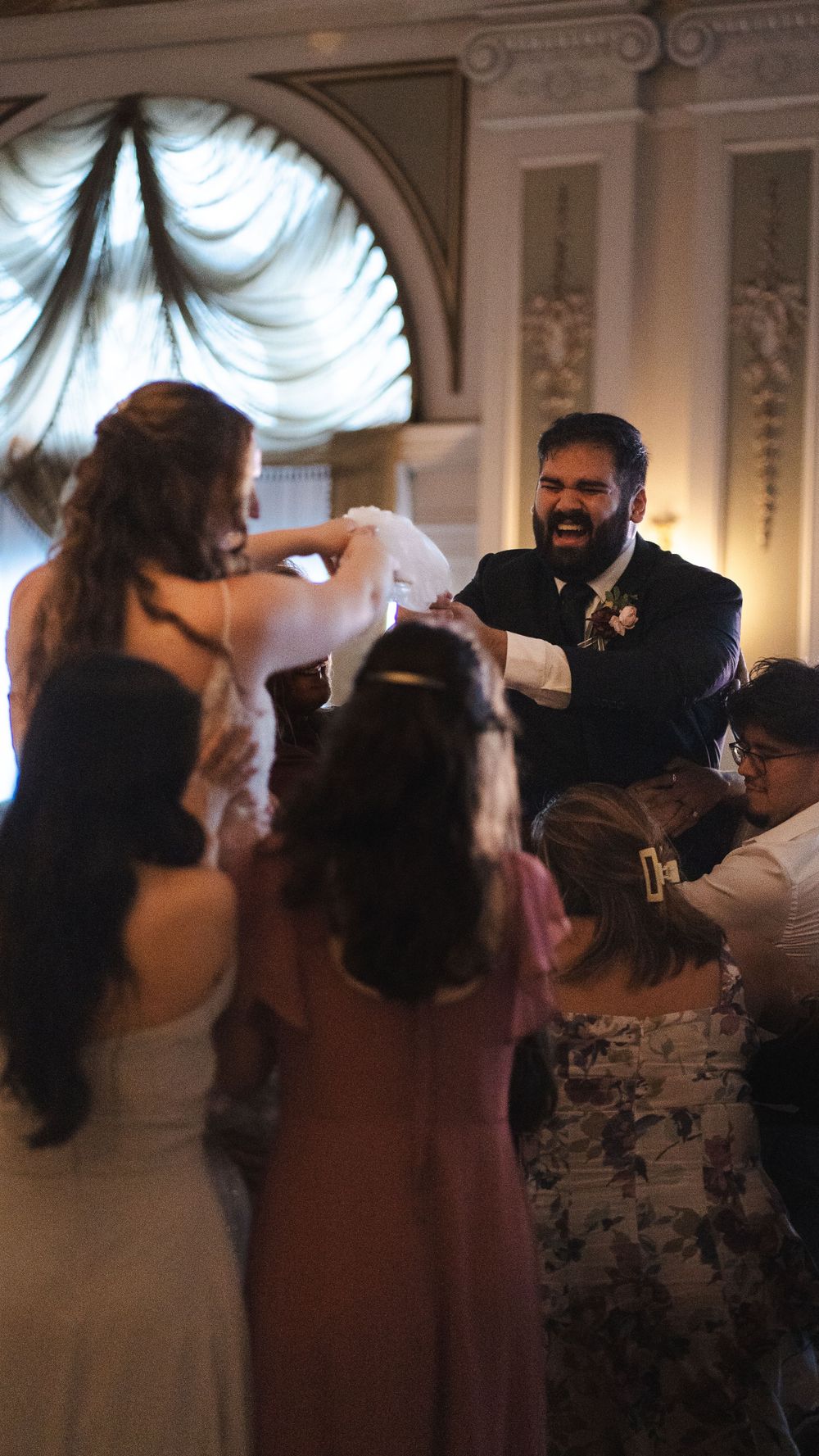 Lively wedding dance celebration taking place in an ornate ballroom with elegant decor.