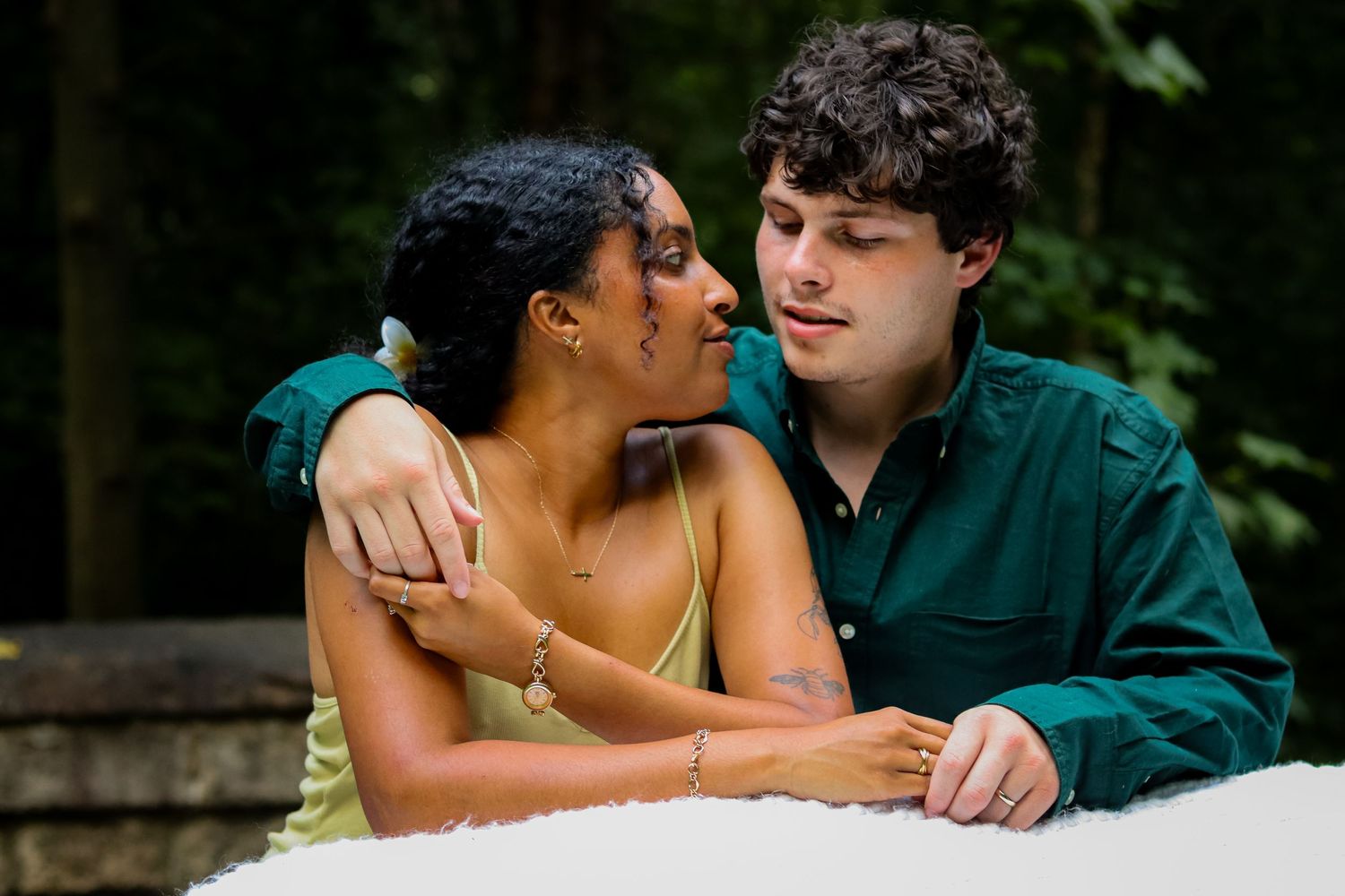 A romantic outdoor portrait of a couple gazing at each other with affection in a natural setting.