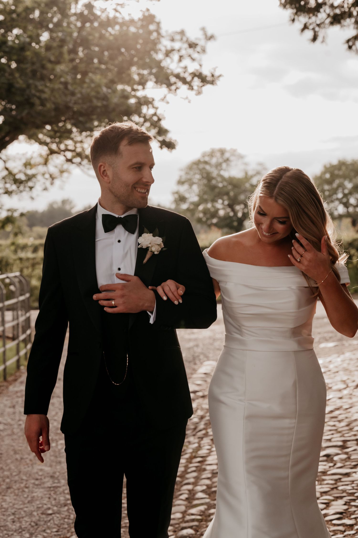 Newlyweds sit in a classic white car with beautiful floral bouquet.