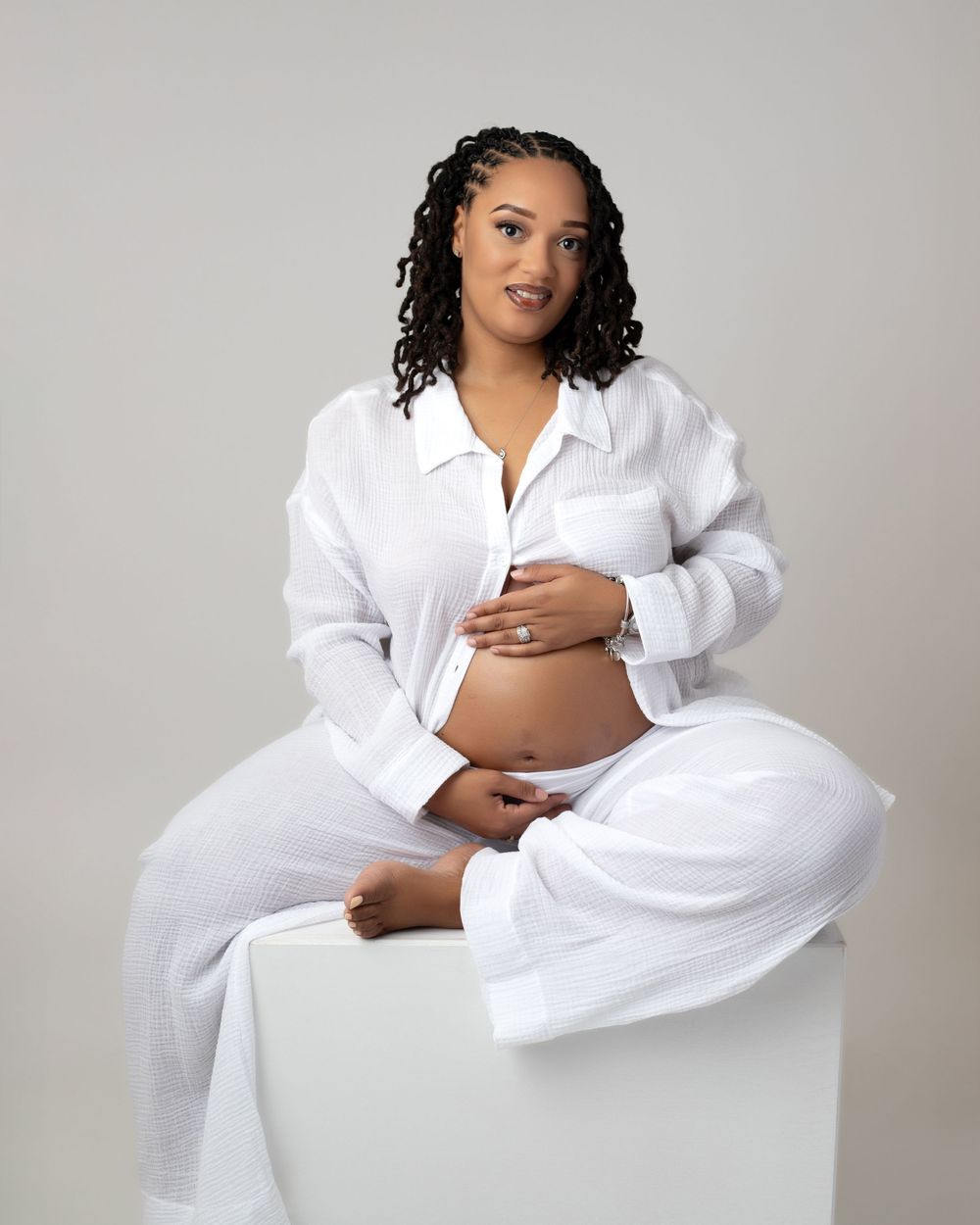 A series of classic maternity portraits showing a person in white clothing against a neutral white backdrop.
