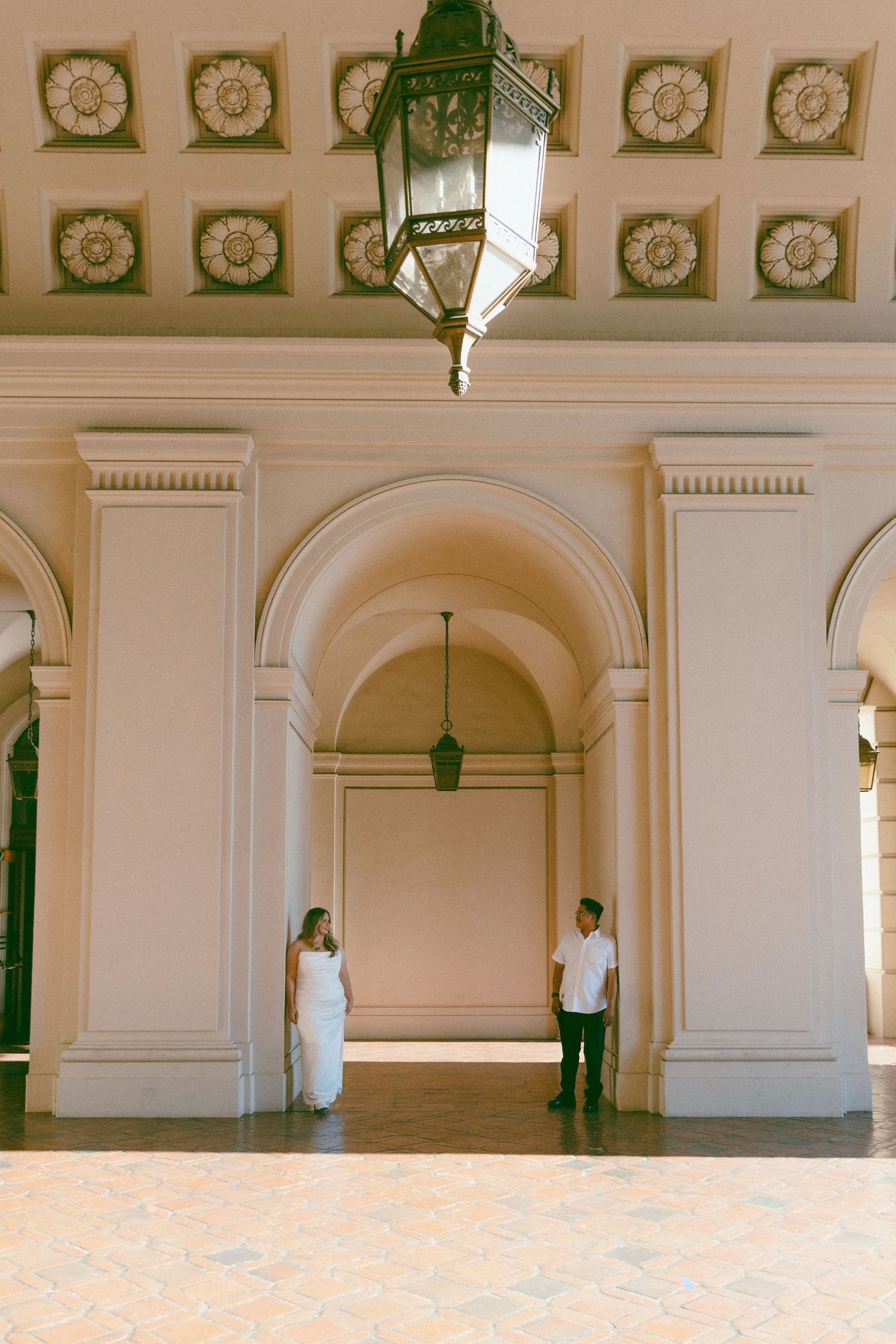 A series of four connected images showing an ornate white interior hallway with arched doorways and decorative ceiling details.