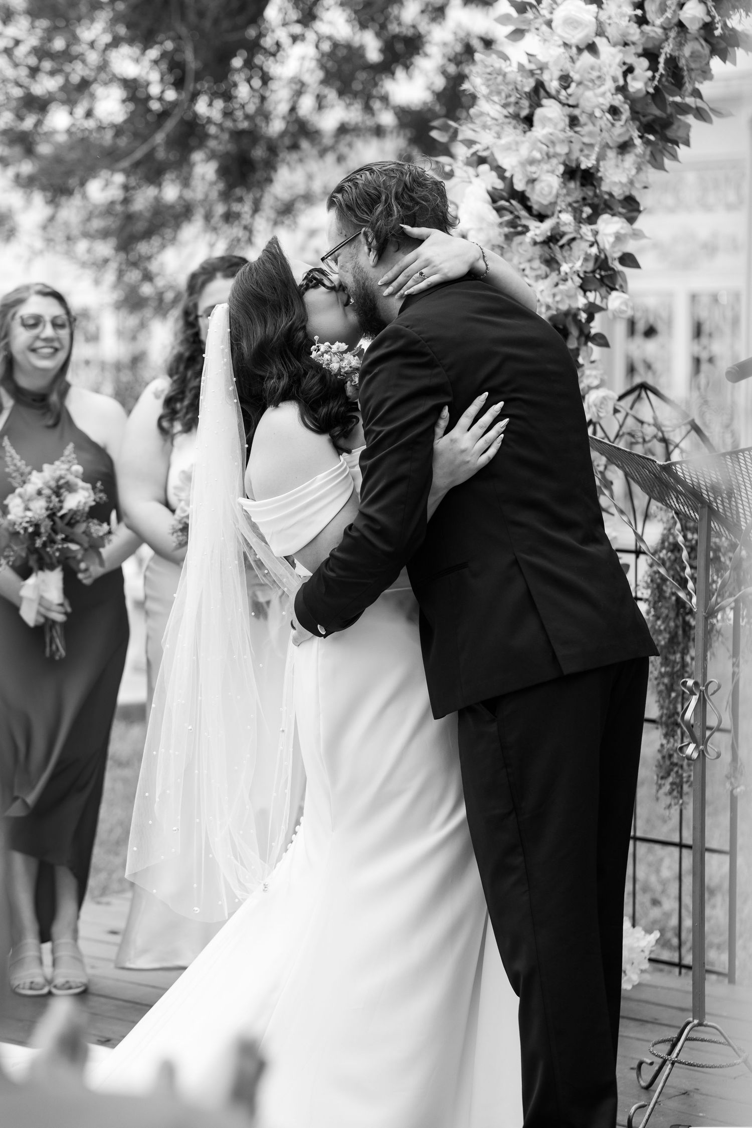A tender moment between newlyweds in elegant white wedding attire.
