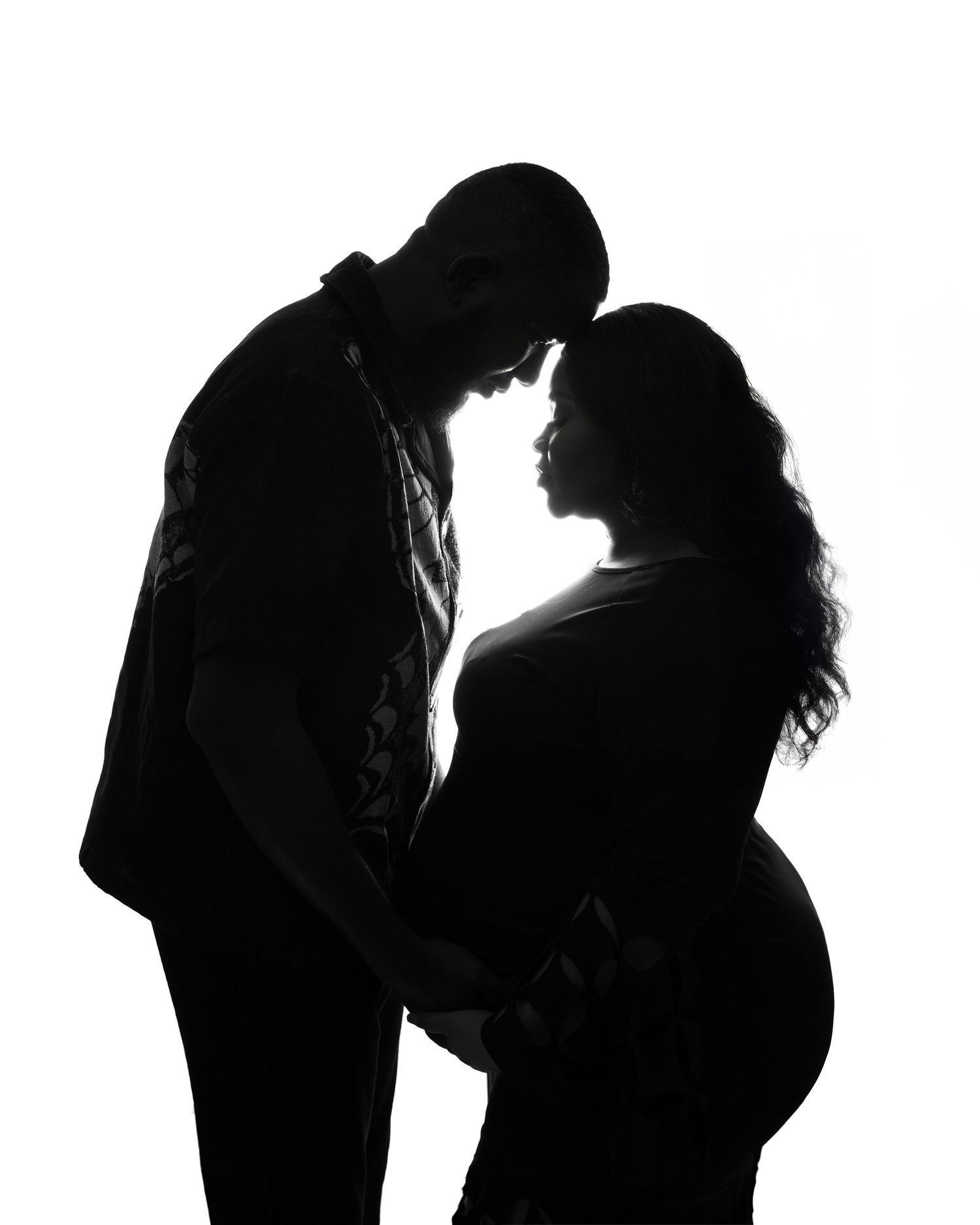 Silhouettes of a couple in romantic poses against a dark background.