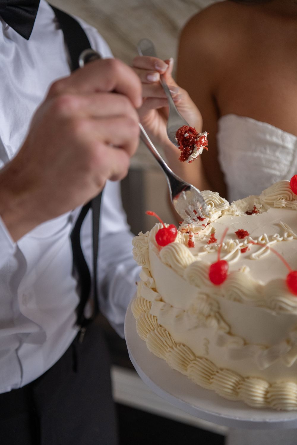 A series of photos showing hands decorating a white frosted cake with cherries and piped details.