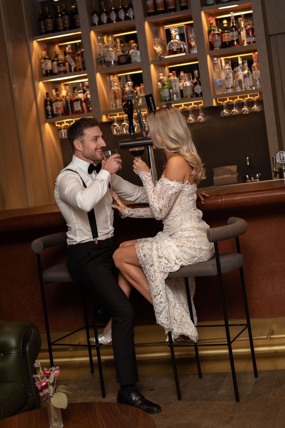 A sequence of playful wedding photos captured at a dimly lit bar with bottles in the background. Royal Hotel Prince Edward County