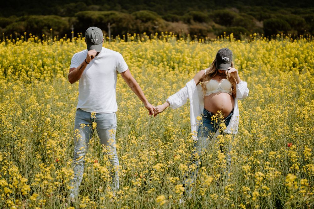 Family walking through vibrant yellow wildflower field during sunset.