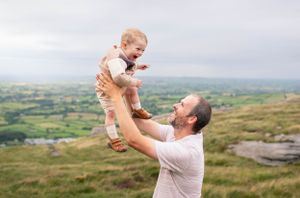 Joyful playtime against a backdrop of rolling hills and cloudy skies.