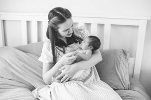A quiet moment of bonding in a white bedroom with soft natural light.