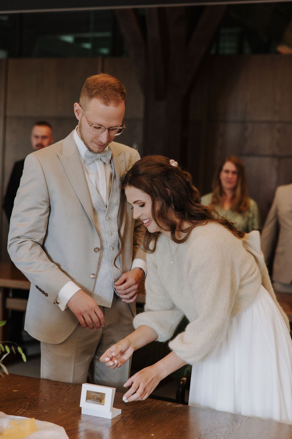 Couple in formal attire cutting their wedding cake during reception.