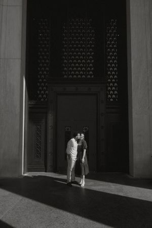 A person stands in stark contrast against a dark doorway creating dramatic shadows and light in architectural composition.