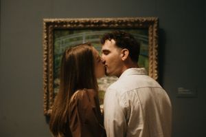 A couple shares an intimate moment while viewing artwork in a museum gallery with an ornate gold frame in the background.