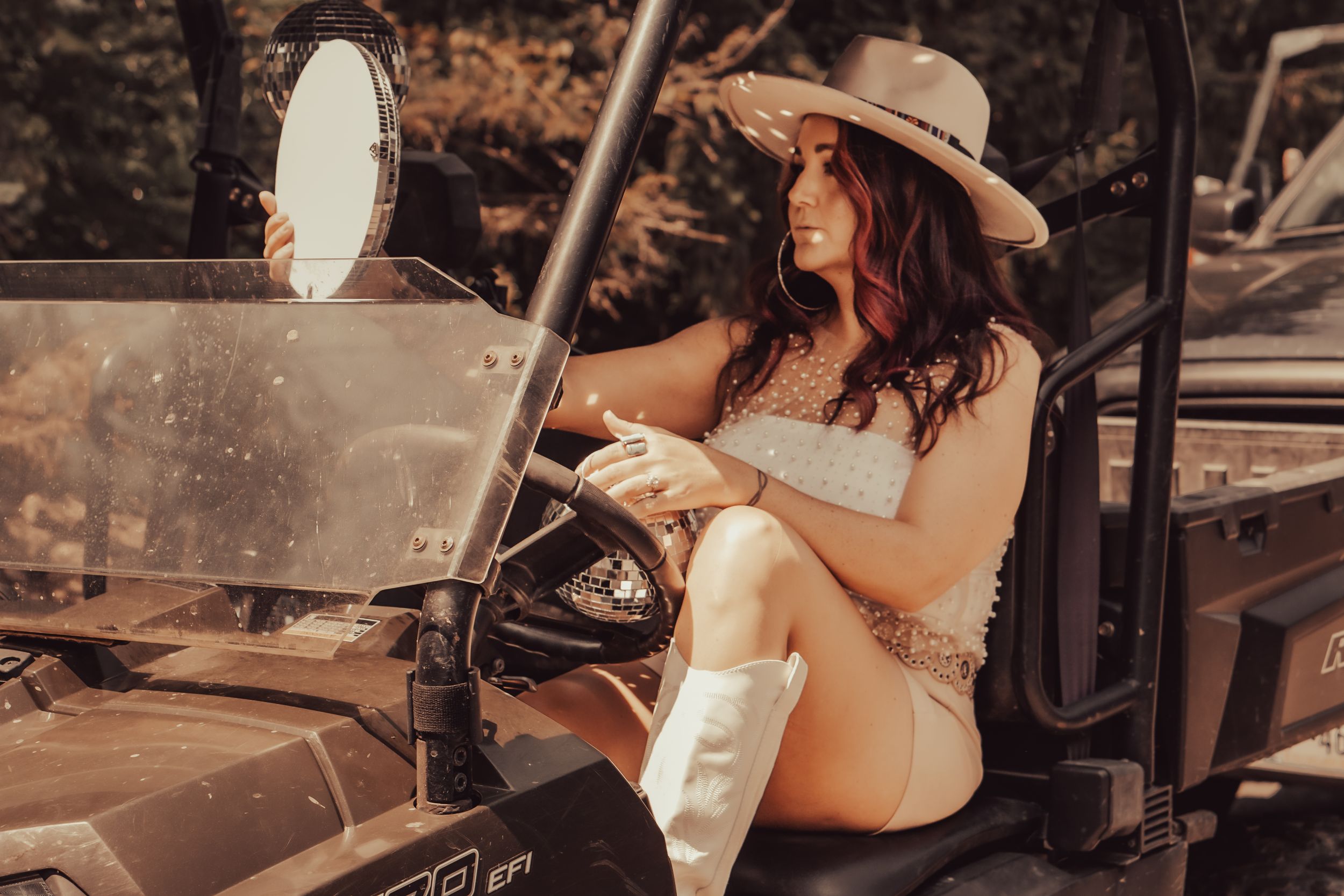 Western style scene with cowboy boots and hat in vintage off-road vehicle.