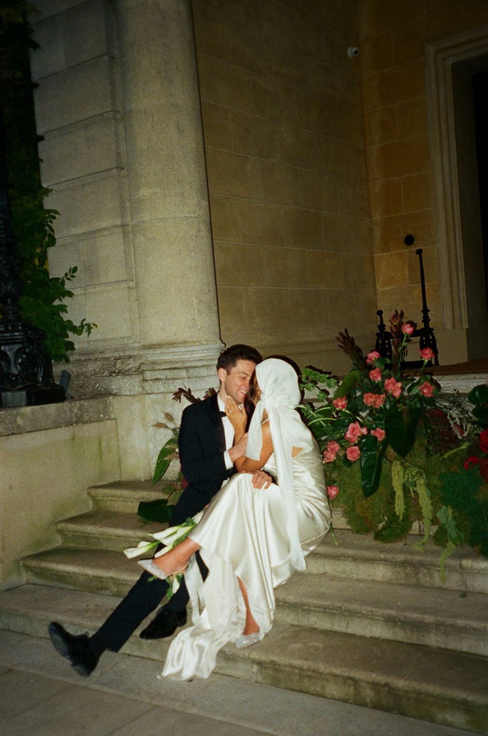 A romantic series of photos showing a couple on stone steps outside a building with pink floral decorations at night.
