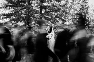 a bride and groom kissing while their wedding party is walking around them