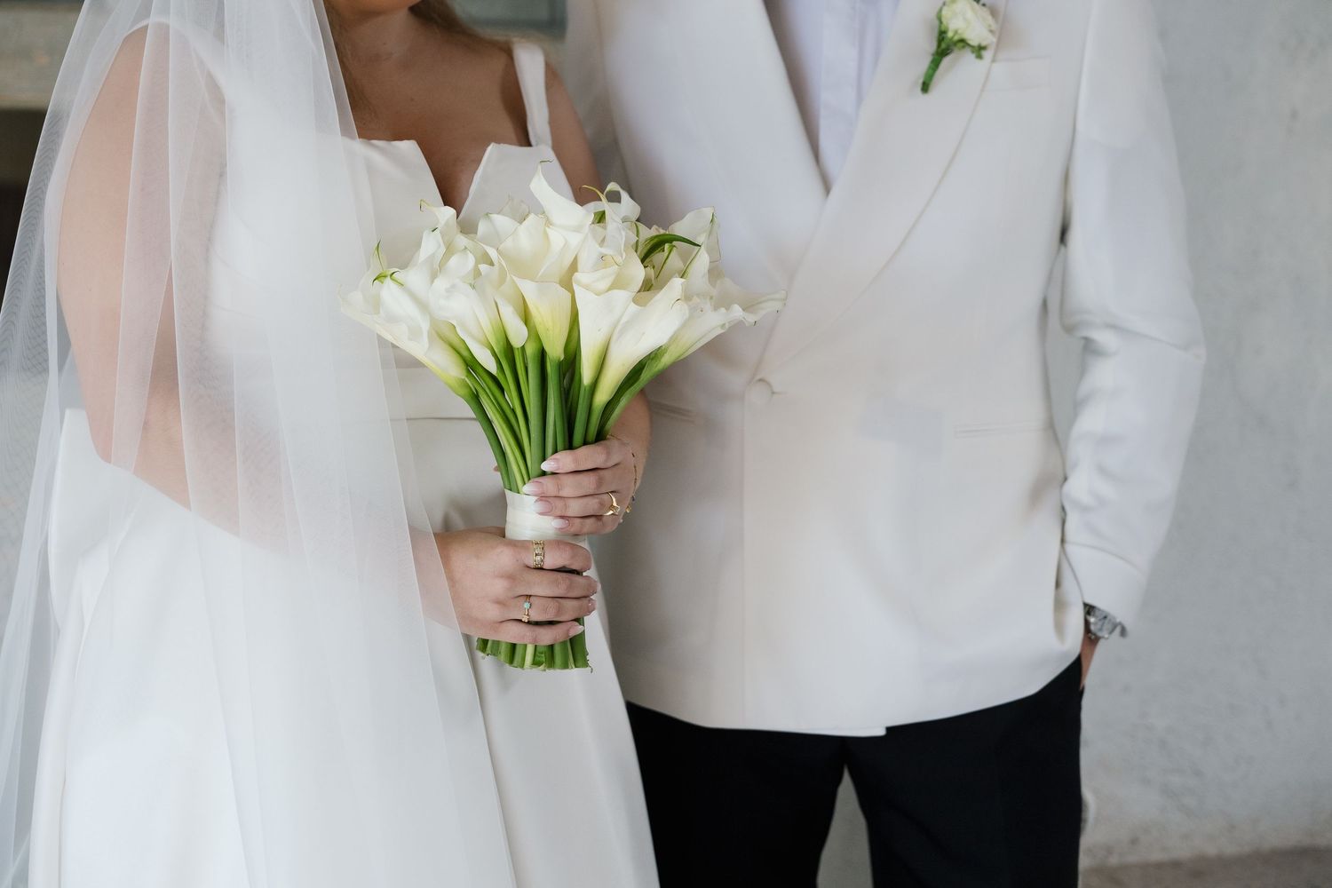 Elegant wedding photography showing white floral bouquets and formal attire details.
