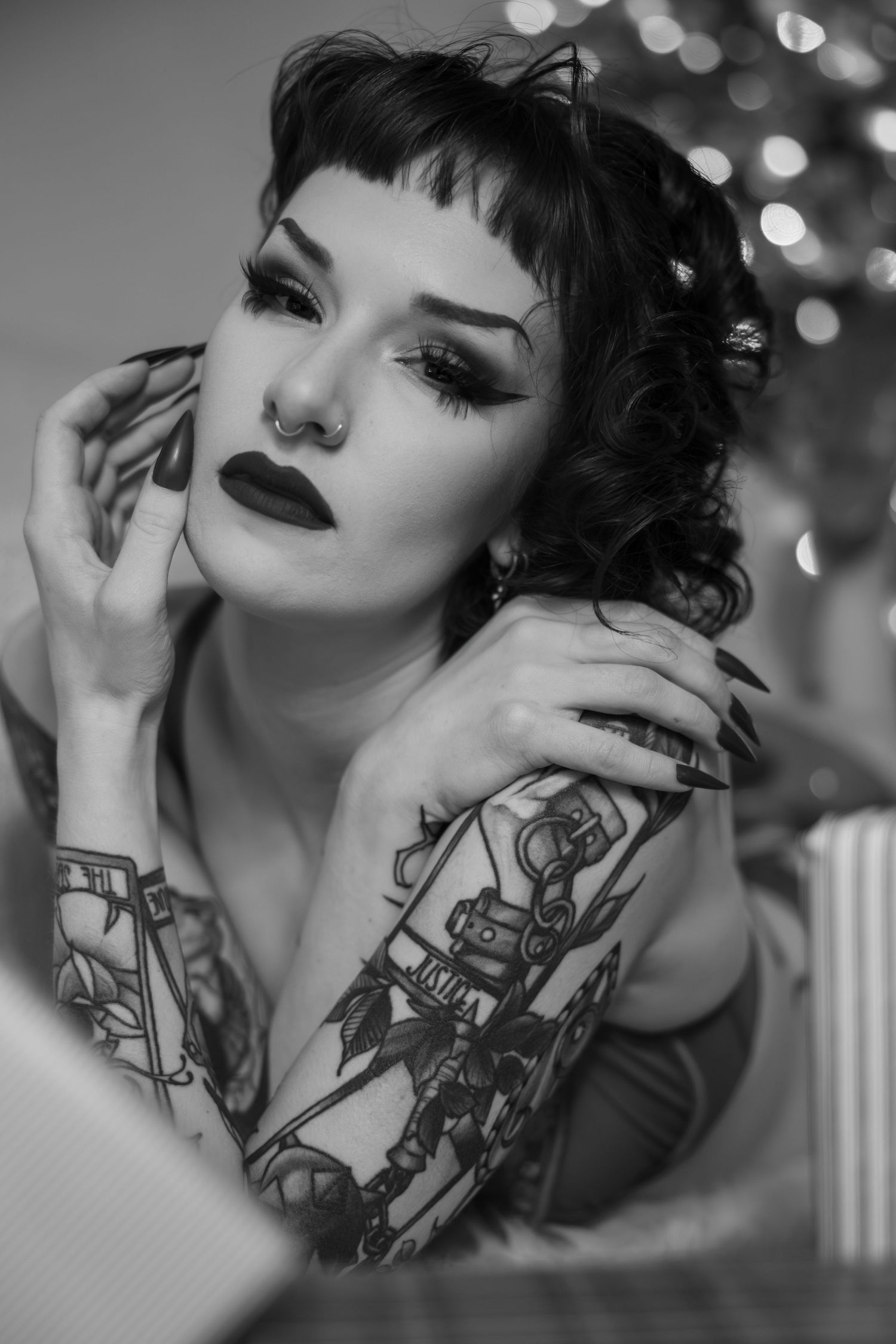 Black and white portrait series showing artistic neck tattoos against bokeh lights in the background.