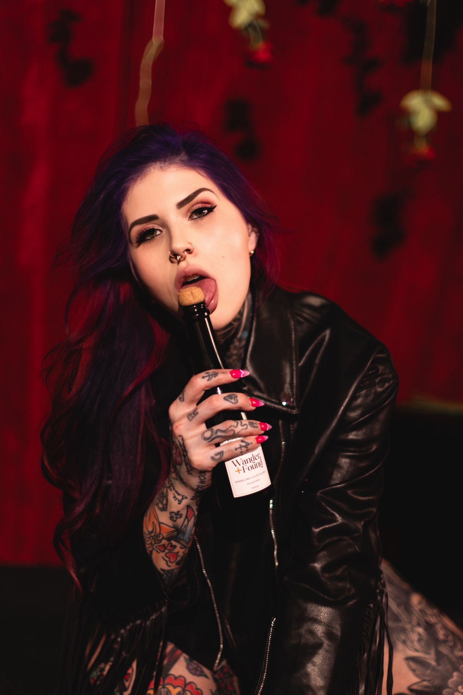 Gothic aesthetic photo series with black leather jacket and dark lipstick against red backdrop.